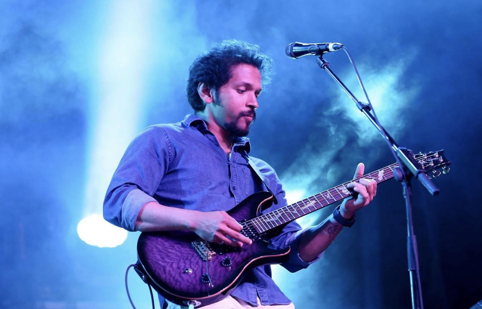 Portrait of guitarist Glen Fernandez holding an electric guitar