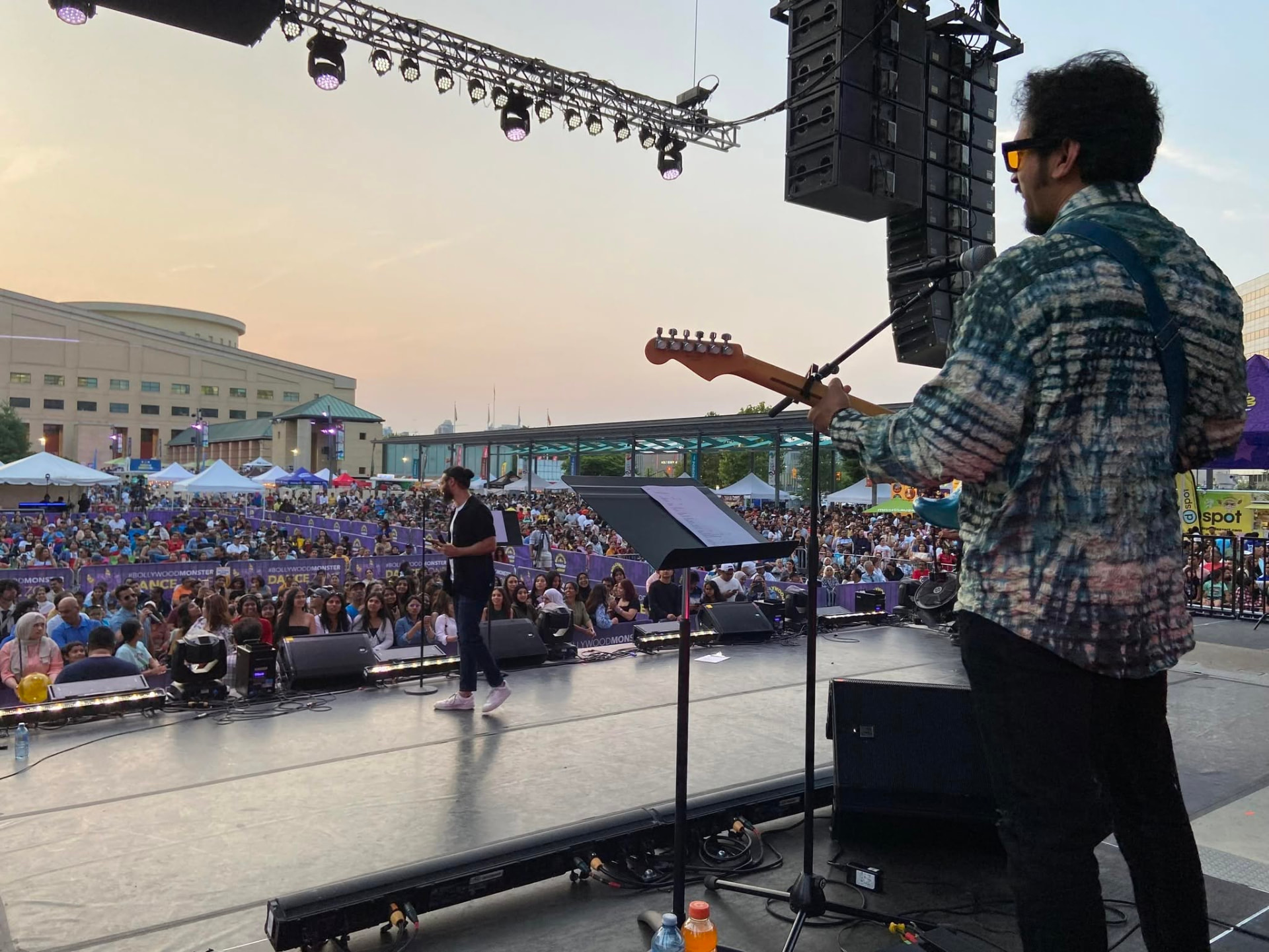 View from the stage over a large festival crowd at sunset