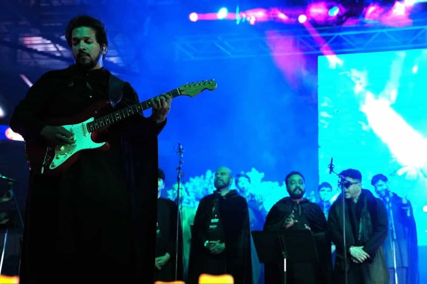 Glen Fernandez playing a Stratocaster under blue stage lights