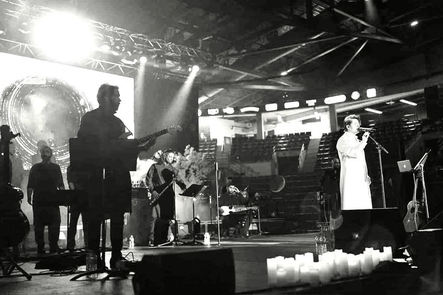 Black and white shot of the full band on a concert stage